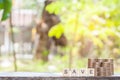 Wooden block with a save word and coins