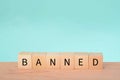 Wooden block with text BANNED. A ban refers to a formal or official prohibition or restriction on a particular activity, action,