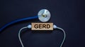 Wooden block with word `GERD` and stethoscope on black background. Medical concept Royalty Free Stock Photo