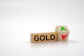 Wooden block with the word GOLD and up and down arrows on the surface. Finance and gold price concept.