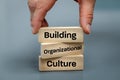 A wooden block with the words Building, Organizational, Culture, Modern approach to working with people in a team, Creative