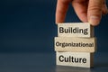 A wooden block with the words Building, Organizational, Culture, Modern approach to working with people in a team, Creative