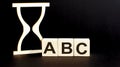 Wooden blocks ABC with wooden sand clock on table. Personal, career or business development, mindset concept Royalty Free Stock Photo