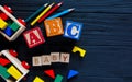 Wooden blocks with A B C letters, abacus toys for creativity development on black background. Educational games for kindergarten Royalty Free Stock Photo