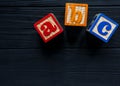 Wooden blocks with A B C letters, toys for creativity development on black background. Educational games for kindergarten, Royalty Free Stock Photo