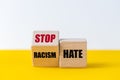 wooden blocks that change the phrase Racism Hate into the slogan stop hate, Beautiful yellow and white background