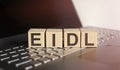 Wooden blocks with EIDL text of concept on the laptop Royalty Free Stock Photo
