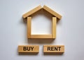 Wooden blocks form the words `buy rent` near miniature house. Beautiful white background, copy space. Business concept Royalty Free Stock Photo