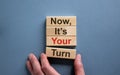 Wooden blocks form the words `now, it`s your turn` on beautiful blue background. Male hand. Beautiful background. Business conc Royalty Free Stock Photo