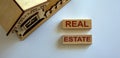 Wooden blocks form the words `real estate` near miniature house Royalty Free Stock Photo
