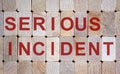 Wooden blocks form the words `serious incident`. Beautiful wooden background