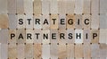 Wooden blocks form the words `strategic partnership`. Beautiful wooden background. Business concept