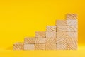 Wooden blocks forming stairway on yellow background. Ladder of success Royalty Free Stock Photo