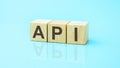 wooden blocks with the letters API, blue background Royalty Free Stock Photo