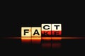 Wooden blocks with letters forming words `Fact` and `Fake`