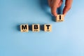 Wooden blocks with the letters MBTI on blue background. Personality typology. Psychology test for human types.MBTI - Myers-Briggs
