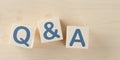 Wooden blocks with the letters Q and A on wooden table background, question and answer business concept