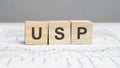 a wooden blocks with the letters USP written on it on a white background