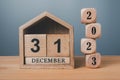 Wooden blocks lined up with 2023 numbers and wooden house on December 31st, last day of the year goal concept