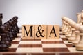 Wooden Blocks With Mergers And Acquisitions Text On Chess Board Royalty Free Stock Photo