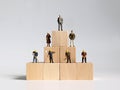 Wooden blocks and miniature people. The concept of social stratification.