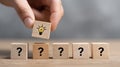 Wooden blocks with question marks and hand holding block with light bulb symbolizing idea and solution concept in soft light Royalty Free Stock Photo