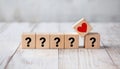 Wooden Blocks with Question Marks and Red Heart Symbol on Rustic White Background Royalty Free Stock Photo