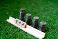 Wooden blocks spelling EPF with a stack of coins growing in size set on grass Royalty Free Stock Photo