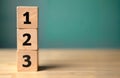 Wooden blocks stacked in order 1, 2, 3. Simple visual aids representing steps in process. Ideal for education, business