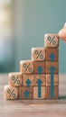 Wooden blocks with % symbols and arrows stacked in ascending order, growth concept