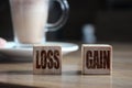 Wooden blocks on wooden table with Loss and Gain words. Money finance business concept