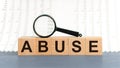 Wooden Blocks with the text: Abuse with magnifying glass Royalty Free Stock Photo