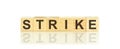 Wooden blocks with the text: strike. The text is written in black letters and is reflected in the mirror surface of the table Royalty Free Stock Photo