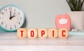 Wooden Blocks with the text: topic with magnifying glass. Topic word made with building blocks Royalty Free Stock Photo