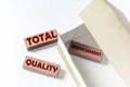 Wooden blocks with text TQM Total Quality Management in a box on a white background
