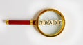 Wooden Blocks with the text: TRADE on a magnifying glass
