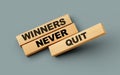 Wooden blocks with winners never quit word on colorful isolated background 3d illustration