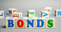 Wooden blocks with the word Bonds. A bond is a security that indicates that the investor has provided a loan to the issuer.