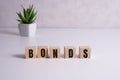 Wooden blocks with the word Bonds. A bond is a security that indicates that the investor has provided a loan to the Royalty Free Stock Photo