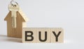 Wooden blocks with the word BUY , house. The concept of the high cost of rent for an apartment or home. Interest rates are rising Royalty Free Stock Photo