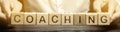 Wooden blocks with the word Coaching in the hands of a man. Self improvement. Achieving goals through training and guidance. Coach