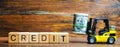 Wooden blocks with the word Credit and forklift. Loan provided by the lender to the borrower at a certain interest for the use of Royalty Free Stock Photo