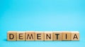 Wooden blocks with the word Dementia. Decrease in cognitive activity and memory. Emotional problems, decrease in motivation,