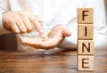 Wooden blocks with the word Fine and a man who calculates the size of the fine. Monetary penalty imposed in the form of punishment Royalty Free Stock Photo