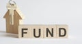 Wooden blocks with the word FUND , house. The concept of the high cost of rent for an apartment or home. Interest rates are rising Royalty Free Stock Photo