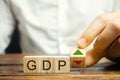 Wooden blocks with the word GDP and up and down arrows. An unstable economy in the country. Financial measure of the market value