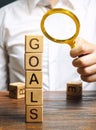 Wooden blocks with the word Goals and businessman. The concept of achieving business goal. Reaching new heights. Execution of a Royalty Free Stock Photo