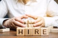 Wooden blocks with the word Hire. Headhunter selects a person from the crowd. Good choice. Human Resource Management. Recruiting