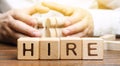 Wooden blocks with the word Hire. Headhunter selects a person from the crowd. Good choice. Human Resource Management. Recruiting