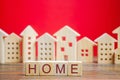 Wooden blocks with the word Home and miniature houses.